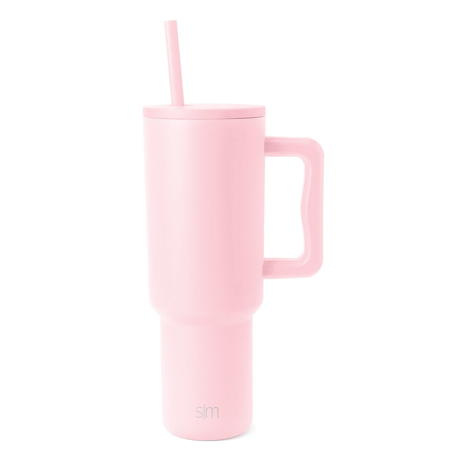 Pale pink insulated tumbler with wide handle, fitted lid and matching straw on white background. Simple Modern logo visible on body.